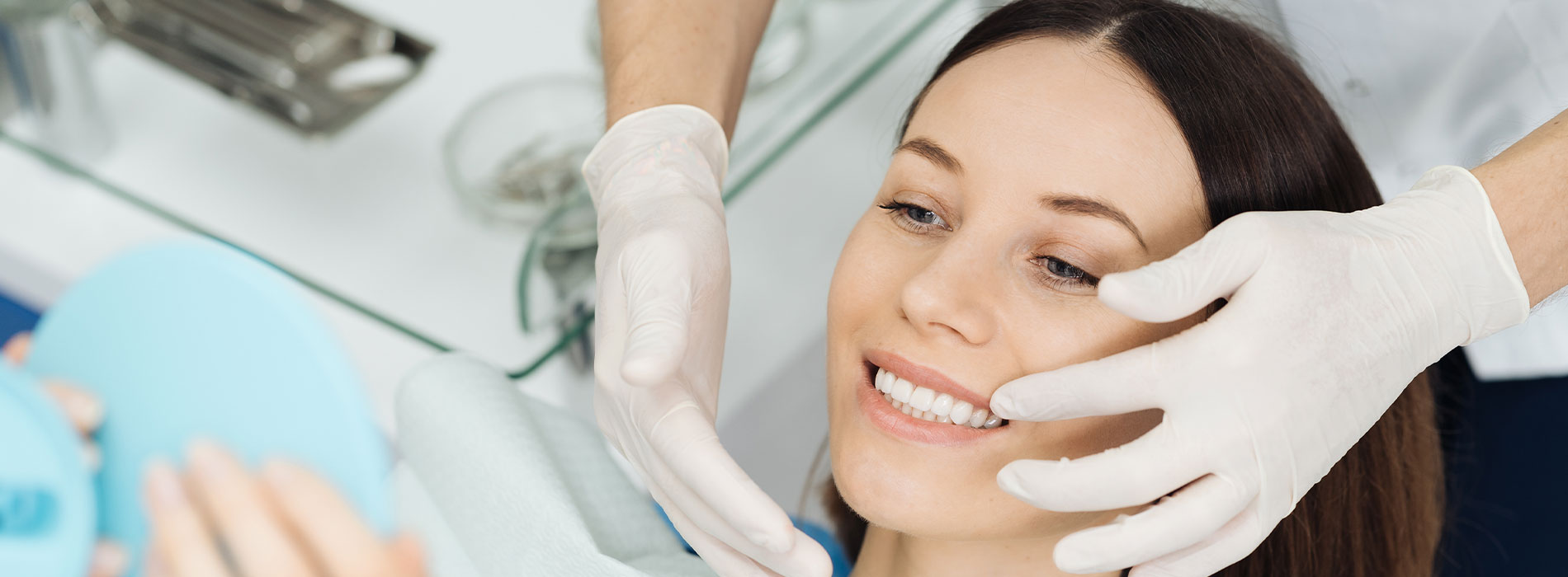 A woman receiving facial treatment from a professional in a salon setting.